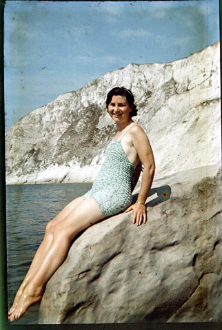 Dufaycolor transparency of woman in swimming costume on rock with sea. Circa 1936.